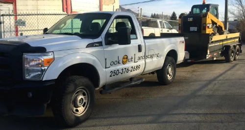 Landscaping truck pulling an excavator